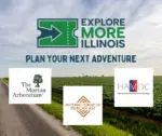Promotional banner for "Explore More Illinois," inviting visitors to "Plan your next adventure." A scenic rural landscape features winding roads through lush green cornfields under a partly cloudy sky, with a solitary tree on the horizon. Overlaid are three cultural attraction logos: The Morton Arboretum's iconic tree emblem in white on black; the National Museum of Mexican Art's diamond-patterned design in terracotta tones; and the Haitian American Museum of Chicago's acronym in red, white, and blue stripes. The main title "EXPLORE MORE ILLINOIS" appears in bold green and navy text with a directional arrow graphic.